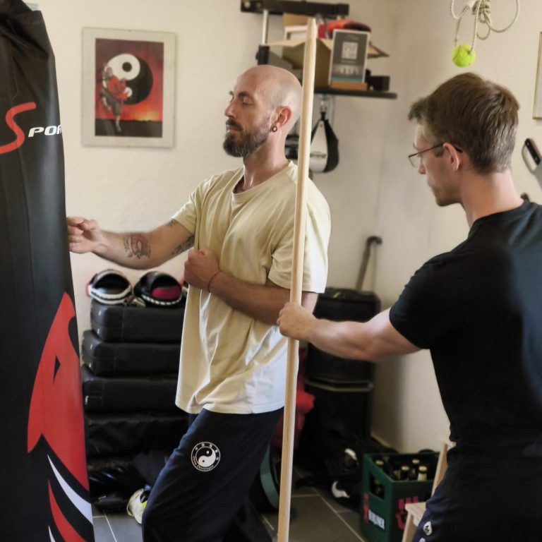 Schlagtraining am Sandsack. Sifu Markus Bischoff kontrolliert die korrekte Körperhaltung beim Fauststoß.